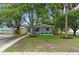 Charming house with a manicured lawn and a quaint front porch, enhanced by mature trees and an American flag at 501 74Th N Ave, St Petersburg, FL 33702