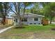Charming home featuring a manicured lawn and a quaint front porch, enhanced by mature trees and an American flag at 501 74Th N Ave, St Petersburg, FL 33702