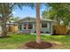 Charming house with a manicured lawn and a quaint front porch, enhanced by mature trees and an American flag at 501 74Th N Ave, St Petersburg, FL 33702