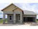 New home construction featuring an attached two-car garage and stone-detailed columns at 5028 Chapel Row Ave, Apollo Beach, FL 33572