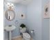 Powder room featuring pedestal sink, toilet with plant decor, and framed art with baby blue walls at 507 S Willow Ave, Tampa, FL 33606