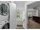 Laundry area with stacked washer/dryer adjacent to hallway and view into bedroom at 507 S Willow Ave, Tampa, FL 33606