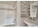 This bathroom features a tiled shower-tub combo and a pedestal sink with built-in shelving at 508 2Nd St, Indian Rocks Beach, FL 33785