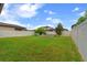 Lush backyard featuring a well-maintained lawn, tasteful landscaping, and a secure privacy fence at 5239 Fallen Leaf Dr, Riverview, FL 33578