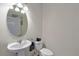 Bright half bathroom with pedestal sink, oval mirror, and white toilet at 5239 Fallen Leaf Dr, Riverview, FL 33578