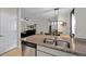 Kitchen island with granite countertop and stainless steel sink overlooking the living area at 5239 Fallen Leaf Dr, Riverview, FL 33578