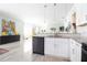 Open-concept kitchen featuring white cabinets, granite countertops, and modern appliances flowing into the dining area at 5528 40Th N St, St Petersburg, FL 33714