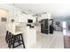 Modern kitchen with white cabinetry, stainless steel appliances, and a breakfast bar overlooking the living area at 5528 40Th N St, St Petersburg, FL 33714