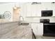 Close-up of a modern kitchen featuring white cabinetry, stainless steel appliances, and granite countertops at 5528 40Th N St, St Petersburg, FL 33714
