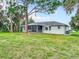 Beautiful home exterior featuring a large backyard with mature trees and lush grass at 5580 S Salford Blvd, North Port, FL 34287