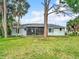 The home features a spacious backyard with lush green grass and mature trees at 5580 S Salford Blvd, North Port, FL 34287