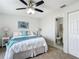 Comfortable bedroom with ceiling fan, soft carpet, and an attached bathroom at 5580 S Salford Blvd, North Port, FL 34287