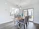 Sunlit dining area with a stylish table set, modern lighting, and sliding glass doors to an outdoor space at 5580 S Salford Blvd, North Port, FL 34287