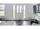Bright foyer with a glass paneled front door, wood flooring and stylish console table at 5580 S Salford Blvd, North Port, FL 34287