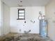 Functional utility room with essential plumbing, an electric water heater, and a practical space for maintenance at 5580 S Salford Blvd, North Port, FL 34287