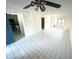 Living room featuring tile floors, a ceiling fan, and a view into the kitchen at 6342 Newtown Cir # A4, Tampa, FL 33615