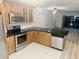 Well lit kitchen with stainless steel appliances, dark countertops, and adjacent living area at 6344 Newtown Cir # B2, Tampa, FL 33615