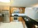 Well lit kitchen with stainless steel appliances, dark countertops, wooden cabinets and tile floor at 6344 Newtown Cir # B2, Tampa, FL 33615