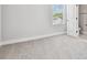 Bedroom featuring modern neutral carpet, natural light, and an ensuite bathroom at 6605 N Nebraska Ave # 23, Tampa, FL 33604