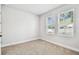 Bright, carpeted bedroom with two windows providing natural light at 6605 N Nebraska Ave # 23, Tampa, FL 33604