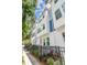 Modern townhome exterior with white facade, blue accents, black fence and lush landscaping at 6605 N Nebraska Ave # 23, Tampa, FL 33604
