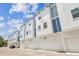 Row of modern townhomes with white exteriors, blue accents and attached garages at 6605 N Nebraska Ave # 23, Tampa, FL 33604