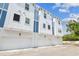 Exterior elevation of modern townhouse featuring attached garages and blue accents at 6605 N Nebraska Ave # 23, Tampa, FL 33604