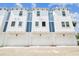 Modern townhome exterior featuring white facade, blue accents, and attached garages at 6605 N Nebraska Ave # 23, Tampa, FL 33604
