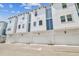 White and blue modern townhome exteriors with attached garages under a bright sky at 6605 N Nebraska Ave # 23, Tampa, FL 33604