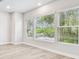 Bright living room featuring three large windows with views of lush greenery at 6605 N Nebraska Ave # 23, Tampa, FL 33604