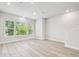 Bright living room featuring three large windows and light woodgrain flooring throughout at 6605 N Nebraska Ave # 23, Tampa, FL 33604