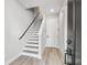 Bright foyer with modern staircase featuring gray wood-look floors and contrasting railing at 6605 N Nebraska Ave # 23, Tampa, FL 33604