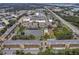 Expansive aerial view of the community with a pond, fountain, pool, tennis court, and nearby shopping at 8158 Eagles Park N Dr, St Petersburg, FL 33709