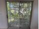 A view of the outdoor balcony shows a sliding door and view of the surrounding trees at 8158 Eagles Park N Dr, St Petersburg, FL 33709