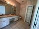Bathroom featuring a double sink vanity, tile floor, and shelving unit at 8158 Eagles Park N Dr, St Petersburg, FL 33709