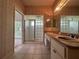 Bathroom with a double sink vanity, a tiled floor, and glass block shower at 8158 Eagles Park N Dr, St Petersburg, FL 33709