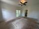 Bedroom with a ceiling fan, sliding glass doors to the balcony, and white walls at 8158 Eagles Park N Dr, St Petersburg, FL 33709