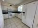 Traditional style kitchen offers white appliances and cabinets, black countertop and tile flooring at 8158 Eagles Park N Dr, St Petersburg, FL 33709