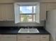 Kitchen sink and countertop with white cabinets and a window overlooking the outside view at 8158 Eagles Park N Dr, St Petersburg, FL 33709
