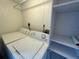 Convenient laundry area with a washing machine, dryer, and shelving for storage at 8158 Eagles Park N Dr, St Petersburg, FL 33709