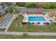Aerial view of a large outdoor pool, shuffleboard, and tennis court with lounge chairs and tables at 8158 Eagles Park N Dr, St Petersburg, FL 33709