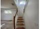Carpetless staircase with white walls and a wood railing at 8158 Eagles Park N Dr, St Petersburg, FL 33709