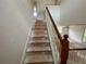 Staircase with wooden railing and carpet removed to expose the treads at 8158 Eagles Park N Dr, St Petersburg, FL 33709