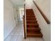 Stairway features wood steps and a wooden handrail, next to a white wall with a mirrored wall opposite at 8158 Eagles Park N Dr, St Petersburg, FL 33709
