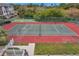 Aerial view of a well-maintained tennis court with red and green surface and surrounding greenery at 8158 Eagles Park N Dr, St Petersburg, FL 33709