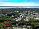 An aerial view of a home nestled among dense trees, with a lake in the background at 910 Kingscote Ct, Safety Harbor, FL 34695