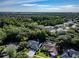 Expansive aerial view showcasing a neighborhood with lush greenery and a glimpse of a distant lake at 910 Kingscote Ct, Safety Harbor, FL 34695