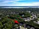 Aerial view of a neighborhood with a nearby lake, surrounded by verdant trees, highlighting the property's location at 910 Kingscote Ct, Safety Harbor, FL 34695