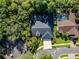 An aerial view showcases the roof, driveway, and backyard with a pool and tennis court at 910 Kingscote Ct, Safety Harbor, FL 34695