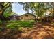 Large backyard with lush lawn, mature trees, and an enclosed lanai, perfect for outdoor activities at 910 Kingscote Ct, Safety Harbor, FL 34695